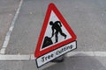 A tree cutting sign used by a tree surgeon on a pavement