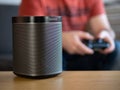 UK, October 2019: Sonos play black wireless speaker with gamer in background