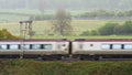 Uk railroad next to rapeseed field and sheep on another side under overcast rain. railway landscape