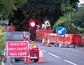 Uk roadworks on village road with red stoplight traffic control