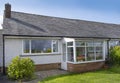 UK 60`s bungalow with slate roof, white quartz render and upvc double glazed windows and front porch