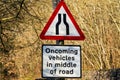 A UK Traffic sign stating road narrows ahead and oncoming wehicles will be in the middle of the road Royalty Free Stock Photo