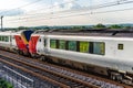 Uk train railroad next to rapeseed field in bloom day view in england. spring railway landscape Royalty Free Stock Photo