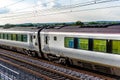 Uk train railroad next to rapeseed field in bloom day view in england. spring railway landscape Royalty Free Stock Photo