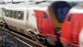 Uk train railroad next to rapeseed field in bloom day view in england. spring railway landscape Royalty Free Stock Photo