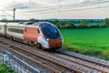 Uk train railroad next to rapeseed field in bloom day view in england. spring railway landscape Royalty Free Stock Photo