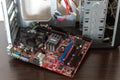 Ukraine - April 25, 2020: Disconnected motherboard of desktop computer near the case on brown background. Hardware components.