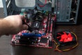 Ukraine - April 25, 2020: Man hand unscrewing the motherboard component with Phillips screwdriver. New PCU cooler