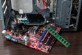 Ukraine - April 25, 2020: Motherboard, port card and RAM near the case on brown background. Hardware components