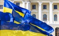 Ukraine blue yellow flags evolving on a wind near town hall classic architecture building with columns arch windows and soft pink