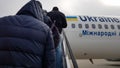 Ukraine, Borispol - March 27, 2020: Unidentified tourists people climb on a plane. Passengers go in a row on the plane. Ukraine