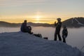 UKRAINE, BUKOVEL - December 2020: Group of Skiers resting on the top of snowed hill drinking warm up drinks and Watching