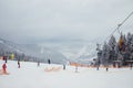 Ukraine. Bukovel - 02 FEBRUARY 2021. Skiers and curbs on the descent from the mountain and christmas trees. Part of the lift up