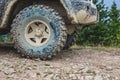 Jeep wheels on a background of trees on top of a mountain. Traveling by jeep through the mountains_ Royalty Free Stock Photo