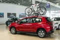 New red family car Peugeot 2008 with a mount on the roof for bicycles in the car dealership. Royalty Free Stock Photo