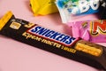 Ukraine, Chernihiv, April 26, 2023: Snickers bar close-up, chocolate bars on pink paper background