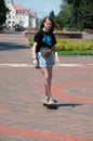 Ukraine, Chernihiv, June 28, 2020: charming teen girl rides on a skateboard in the center of a European city