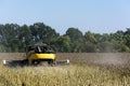 Combine-harvester in a field harvests a sunflower crop for making oil and using it in the food industry Royalty Free Stock Photo