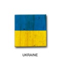 Ukraine flag on a wooden block. Isolated on white background. Signs and symbols