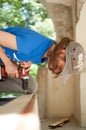 Ukraine, Goshcha, voluntary event, - August, 2021 - skilled young female worker is using power screwdriver drilling