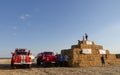 Ukraine, Kharkiv region, field, August 08, 2020 fire trucks on the field near pressed briquettes with advertising advertising Royalty Free Stock Photo
