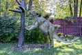 Ukraine, Khmelnitsky, October 2021. A model of a dinosaur, stegosaurus standing on its hind legs near a tree