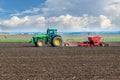 Ukraine, Khmelnytsky region, September 2021. A tractor with a seeder in a field sows a grain of winter wheat