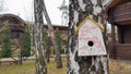 Ukraine, Kiev - April 17, 2020. Beautiful white painted birdhouse made of wood on a birch in the forest near a brown country