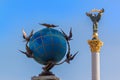 Ukraine, Kiev: Globe with pigeons on the background of the Statue of Liberty