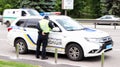 Ukraine, Kiev - June 2, 2020. Police patrol cars provide safety on the roads of Kiev in Ukraine. A male policeman stands near his