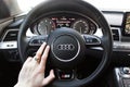 Ukraine, Kiev. March 20, 2015. A man holds the steering wheel of a luxury car. Gold ring on his hand. Audi S8