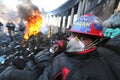 Ukraine. Kiev. Revolutionaries in helmets and masks near flaming tires.