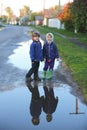 Ukraine, Kiev. Two small friends are standing on a country road near a large puddle.