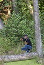 Ukraine, Kyiv, August 25, 2018: A young guy makes a landscape photographing camera Kenon. Removes a small swamp in the forest Royalty Free Stock Photo