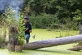 Ukraine, Kyiv, August 25, 2018: A young guy makes a landscape photographing camera Kenon. Removes a small swamp in the forest Royalty Free Stock Photo