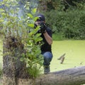 Ukraine, Kyiv, August 25, 2018: A young guy makes a landscape photographing camera Kenon. Removes a small swamp in the forest Royalty Free Stock Photo