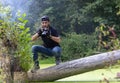 Ukraine, Kyiv, August 25, 2018: A young guy makes a landscape photographing camera Canon. Removes a small swamp in the forest Royalty Free Stock Photo