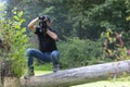 Ukraine, Kyiv, August 25, 2018: A young guy makes a landscape photographing camera Kenon. Removes a small swamp in the forest Royalty Free Stock Photo