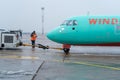 Ukraine, Kyiv - December 29, 2020: The passenger plane is towed for takeoff on a rigid coupling. Foggy airport, bad visibility and