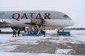 Ukraine, Kyiv - February 12, 2021: Loading luggage into the luggage compartment of the aircraft. Winter airport. A Qatar