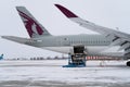 Ukraine, Kyiv - February 12, 2021: Loading luggage into the luggage compartment of the aircraft. Winter airport. A Qatar Airlines