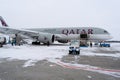 Ukraine, Kyiv - February 12, 2021: Loading luggage into the luggage compartment of the aircraft. Winter airport. A Qatar Airlines