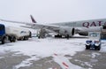 Ukraine, Kyiv - February 12, 2021: Loading luggage into the luggage compartment of the aircraft. Winter airport. A Qatar Airlines