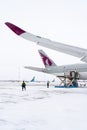 Ukraine, Kyiv - February 12, 2021: Loading luggage into the luggage compartment of the aircraft. Winter airport. A Qatar Airlines