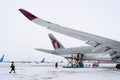 Ukraine, Kyiv - February 12, 2021: Loading luggage into the luggage compartment of the aircraft. Winter airport. A Qatar Airlines