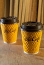 Ukraine, Kyiv - February 17, 2021: Yellow glass of coffee from McDonald`s. Paper glass drink McCafe. offee cup on table with
