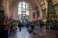 Ukraine, Kyiv - January 7, 2022: railway station building inside. Hall with a christmas tree, escalator and people with