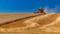 Ukraine. Kyiv. JULY 23, 2022: Modern combine Claas Lexion harvesting grain in the field.Combine harvest on grain field.