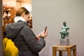 Ukraine, Lviv - December 4, 2018: A woman visitor photographs the bronze sculpture at the museum.
