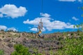 Zipline. The men in the equipment slides on a steel cable. Trolley Track Over the lake. Extreme and active rest.